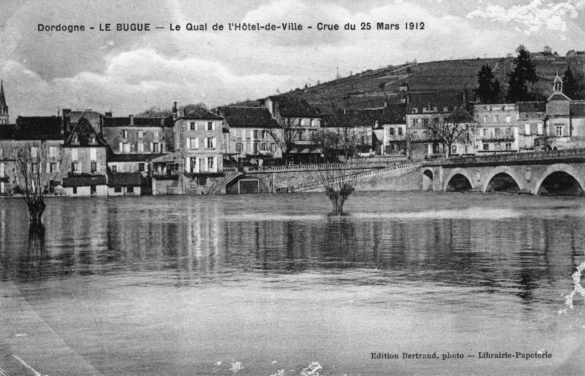 Dordogne – LE BUGUE – Le Quai de l’Hôtel de ville – Crue de la Vézère 25 mars 1912 –
Carte postale – Edition Bertrand, photo – Librairie Papeterie